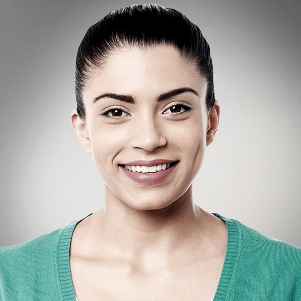 A woman in a green sweater is smiling for the camera